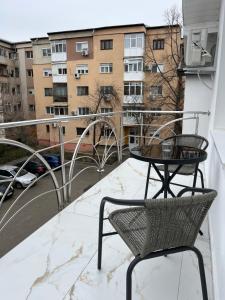 a balcony with a table and chairs on a balcony at Scandinavian AP in Craiova
