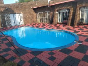 a swimming pool in front of a house at Happy Guest House in Mahikeng