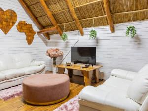 a living room with two white couches and a table at Chicuanga in Chizavane