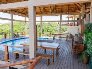 a pool deck with wooden tables and benches at Chicuanga in Chizavane