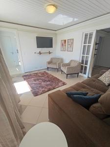 a living room with a couch and a flat screen tv at Bacacheri 5 Estrelas in Curitiba