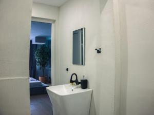 a white bathroom with a sink and a mirror at R34 Boutique Art Hotel in Veliko Tŭrnovo +77 photos