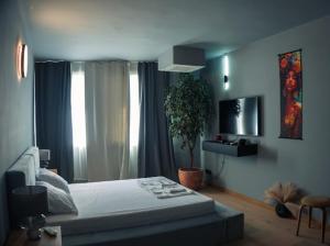 a bedroom with a bed and a potted plant at R34 Boutique Art Hotel in Veliko Tŭrnovo