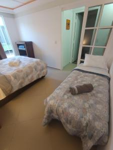a bedroom with two beds and a pillow on the floor at Bacacheri 5 Estrelas in Curitiba +36 photos
