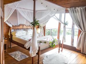 a bedroom with a canopy bed with a window at Chicuanga in Chizavane +290 photos