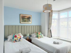 two beds in a room with blue walls at Oxford Guest House in Oxford