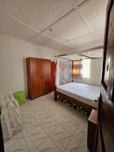 a bedroom with a bed and a chair in it at Malindi Jerere BnB in Malindi