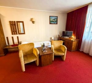 a hotel room with a bed and chairs and a television at Hotel Metro in Kłodzko +37 photos