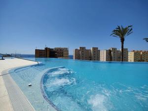a large swimming pool with a city in the background at Sunset Cliffs Sol in Benidorm