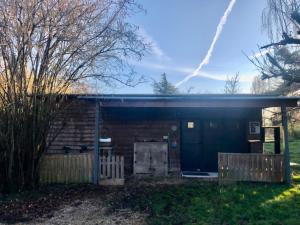 a barn with a door and a fence at Au Passe-Temps in Mettray