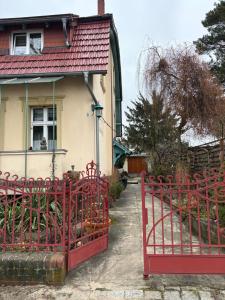 a red gate in front of a house at Gemütliches Studio am Stadtrand Haustierfreundlich in Berlin