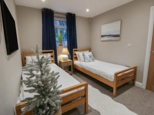 a room with two beds and a christmas tree in it at The Boat House - Port Eynon in Swansea