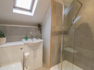 a bathroom with a shower and a sink at The Boat House - Port Eynon in Swansea +26 photos