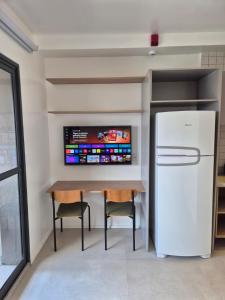 a kitchen with a table and a refrigerator at Apto Stúdio Liberdade novíssimo in São Paulo