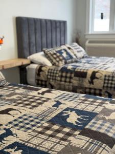 two beds sitting next to each other in a room at The Moosehead in Glenwood