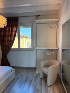 a room with a bed and a chair and a window at Penthouse Apartment Desenzano in Desenzano del Garda +18 photos