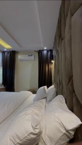 a hotel room with two beds with white pillows at Moor Times Hotel in Benin City