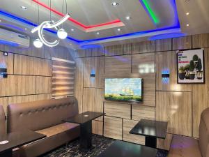 a restaurant with a couch and a tv on a wall at Moor Times Hotel in Benin City