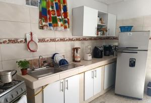 a kitchen with a white refrigerator and a sink at Habitacion privada y central in Barranquilla