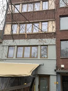 a building with windows and awning in front of it at L'Excelsior Suites in Brasschaat