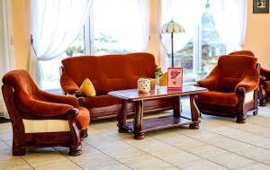 a living room with leather chairs and a coffee table at Hotel Metro in Kłodzko