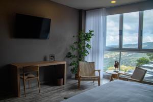 a hotel room with a desk and a desk at Hotel PAUCHÉ Topiario Zapatoca in Zapatoca