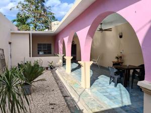 a house with a pink wall and a table at casa bajlum in Valladolid