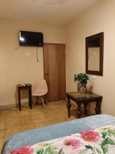 a bedroom with a bed and a table and a mirror at casa bajlum in Valladolid