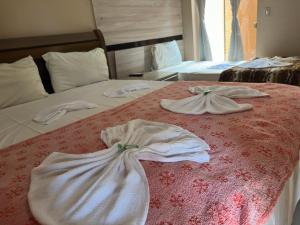 two towels on a bed in a hotel room at Hotel Matrin in Barretos +4 photos