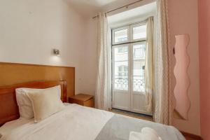 a bedroom with a bed and a window at Baixa GuestHouse in Lisbon