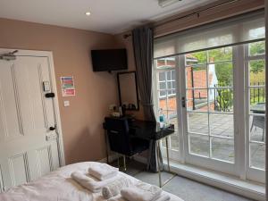 a bedroom with a bed and a window and a desk at The Applewood Regency in Southwell +9 photos