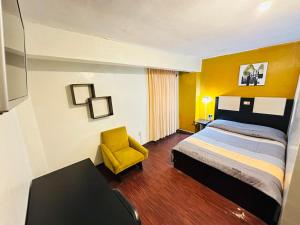 a hotel room with a bed and a yellow chair at Skyline in La Paz