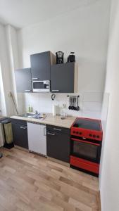 a small kitchen with a red stove top oven at Inselglück in Malchow +6 photos