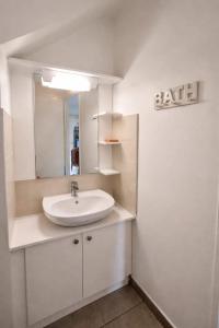 a white bathroom with a sink and a mirror at Duplex Palm Beach - Plage et Rando in Le Gosier +21 photos