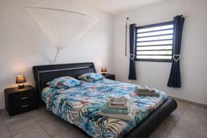 a bedroom with a bed and a window at Duplex Palm Beach - Plage et Rando in Le Gosier