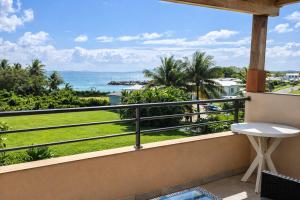 a balcony with a view of the ocean at Duplex Palm Beach - Plage et Rando in Le Gosier