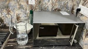 a microwave oven sitting on a counter with a glass at The dream studio in Noida +2 photos