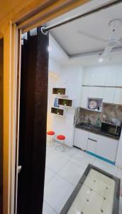 a kitchen with two red stools in a room at The dream studio in Noida