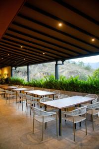a row of tables and chairs in a restaurant at Hotel PAUCHÉ Topiario Zapatoca in Zapatoca