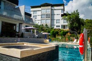 a swimming pool in front of a building at Hotel PAUCHÉ Topiario Zapatoca in Zapatoca