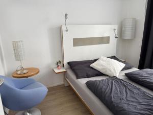 a bedroom with a bed and a blue chair at Dream Holiday Haus in Uetersen
