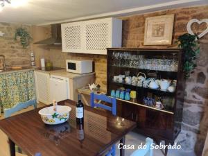 a kitchen with a table with a bottle of wine at Casa do Sobrado-Gralhas-Montalegre in Gralhas