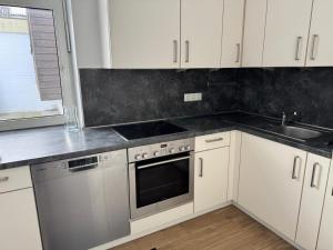 a kitchen with white cabinets and a sink at Dream Holiday Haus in Uetersen