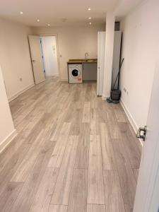 an empty room with wooden flooring in a house at Epsom High Street Apartment 6 in Epsom