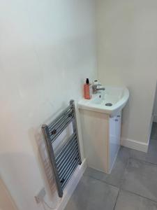 a white bathroom with a sink and a toilet at Epsom High Street Apartment 6 in Epsom