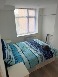 a bed in a room with a window at Epsom High Street Apartment 6 in Epsom