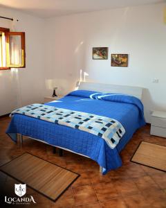 a bed in a room with a blue comforter at Locanda di Cornoleda in Cinto Euganeo +90 photos