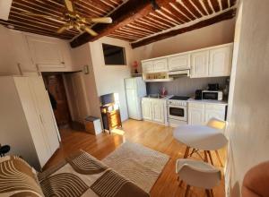 a kitchen with white cabinets and a table and chairs at French Cocoon in Fayence +11 photos