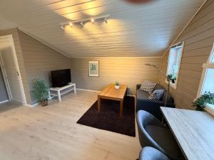 a living room with a table and a tv at Sørlandets paradis in Svenevik