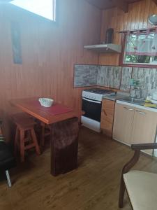 a kitchen with a wooden table and a stove at Cabañas Abrumax in Hornopiren